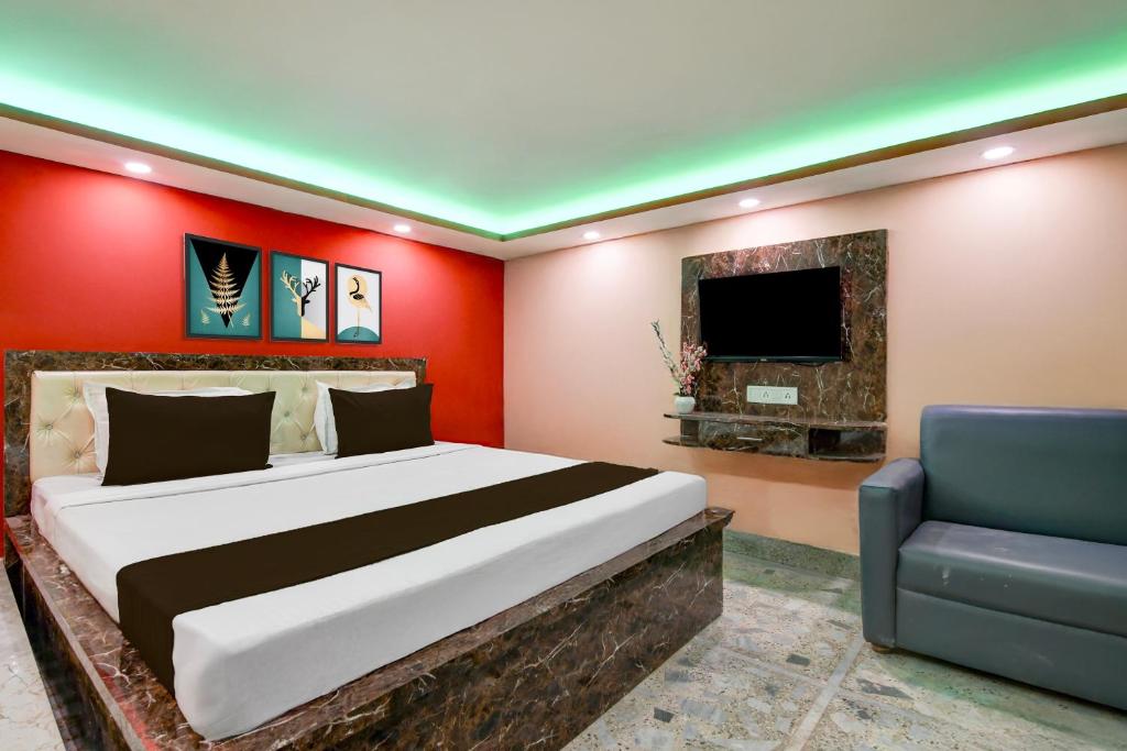 a bedroom with a bed and a tv and a couch at Hotel O Prasad Inn in Ballygunge