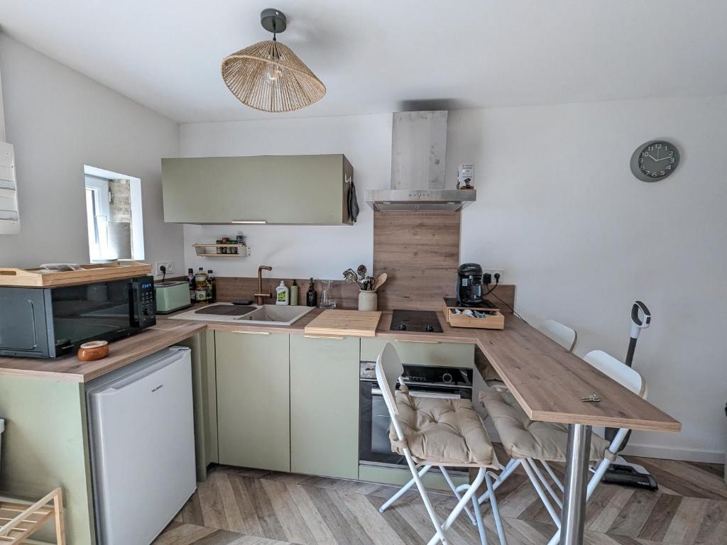Una cocina con una mesa y sillas de madera. en Jo And Manu's Barn, en Falaise