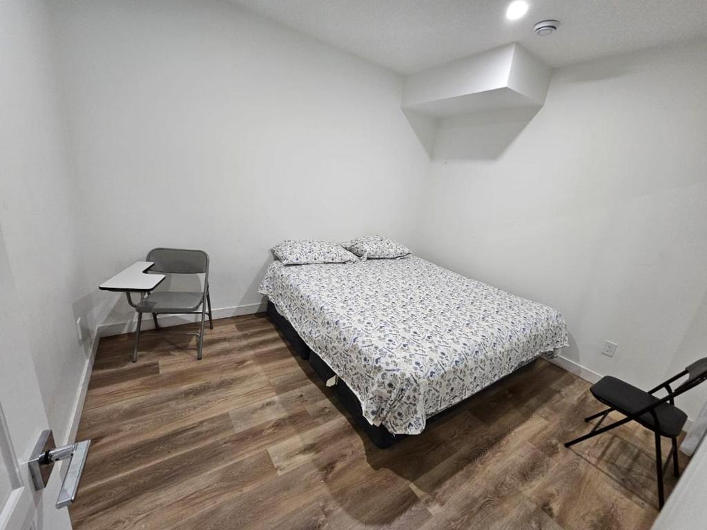 Un dormitorio con una cama y un escritorio. en Private room in Basement suite, en Edmonton