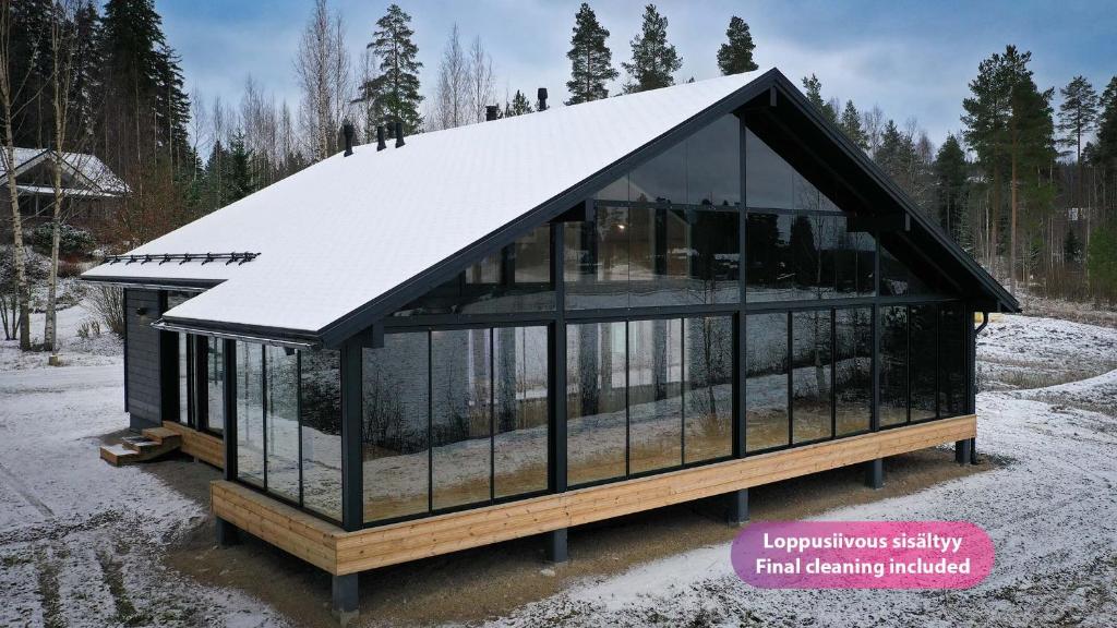 ein Glashaus mit einem schneebedeckten Dach in der Unterkunft Villa Taipale - 8hlö, Himosranta in Jämsä