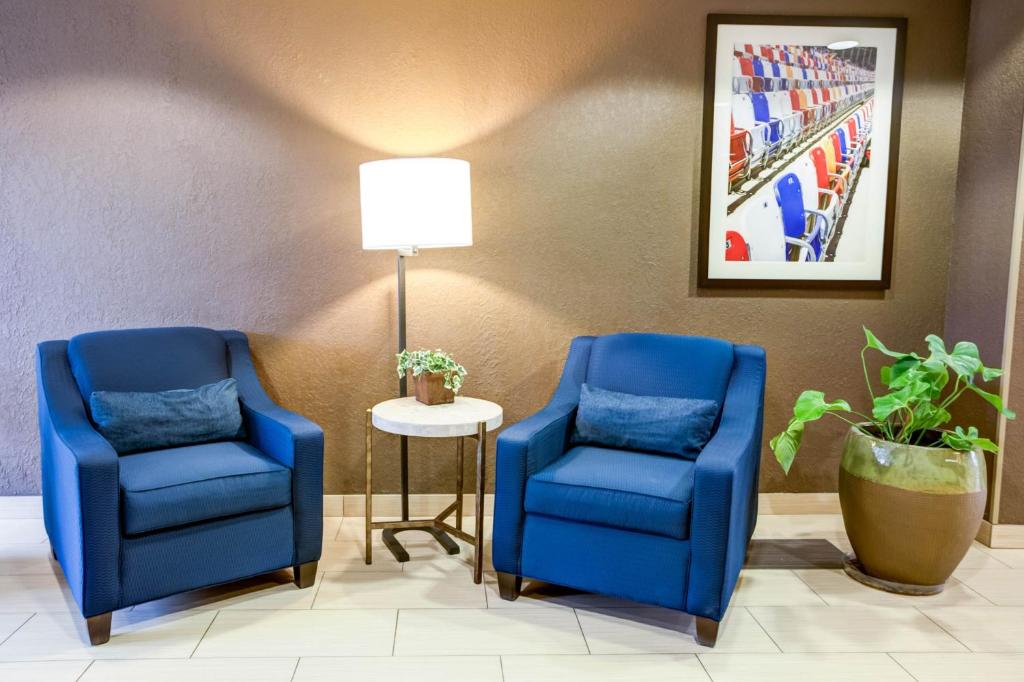 two blue chairs and a lamp in a waiting room at Charlotte Suites by IHG in Charlotte