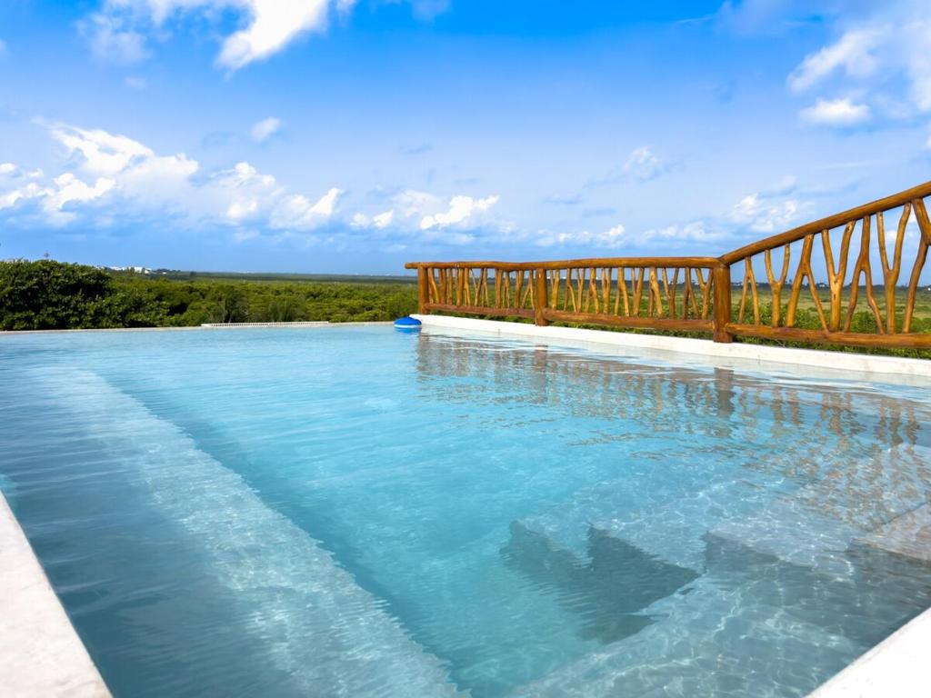 a swimming pool with a wooden fence and blue water at Casa Daniela in Puerto Morelos