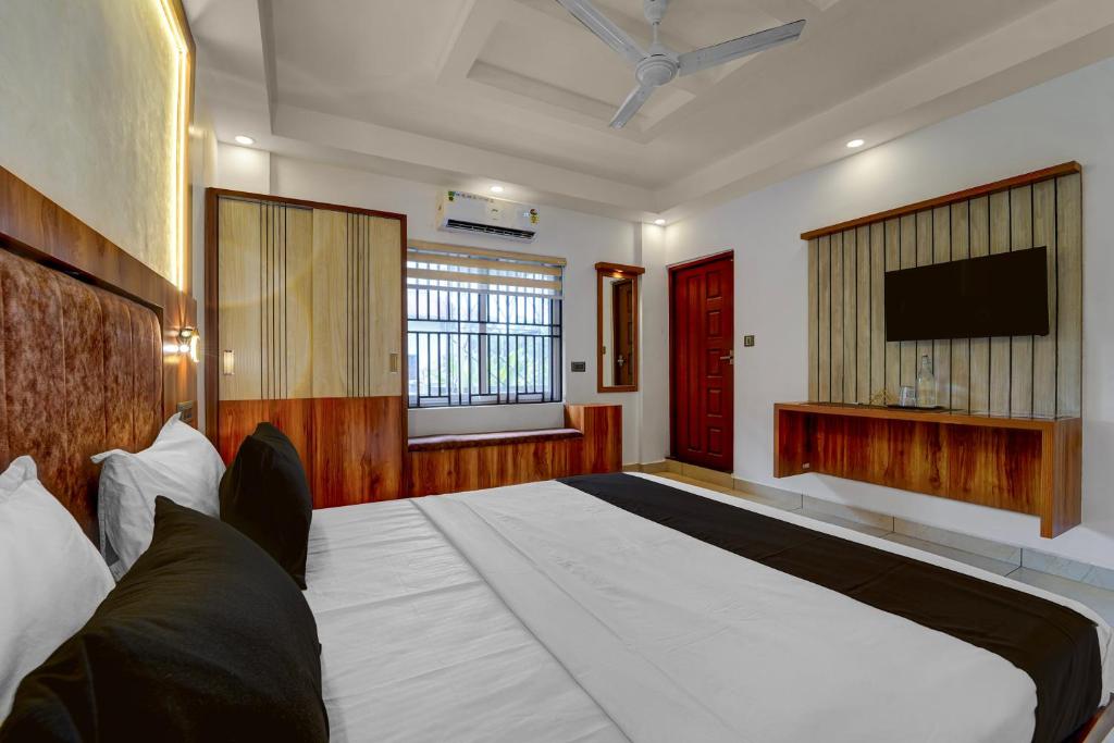 una camera da letto con un letto grande e una TV a schermo piatto di Townhouse Cochin Airport Formerly Skyluxe a Nedumbassery