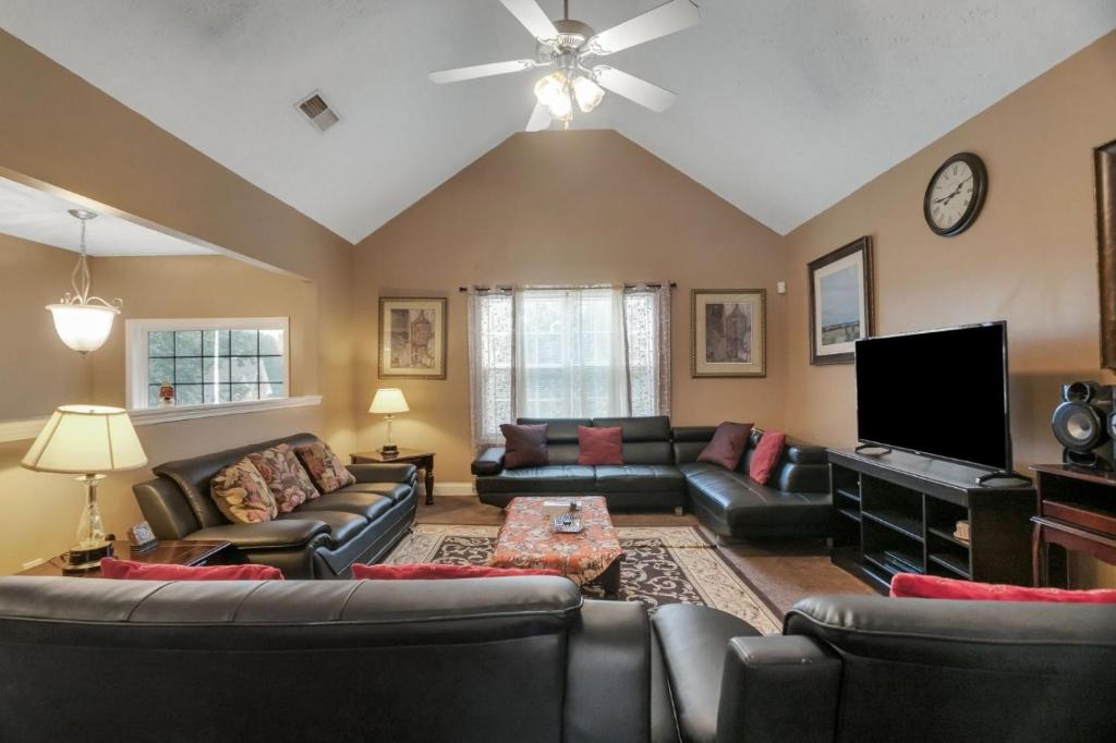 ein Wohnzimmer mit Ledermöbeln und einem Flachbild-TV in der Unterkunft Sleeps 16! • 6BR • Bedroom TVs • Peaceful Suburb in Locust Grove