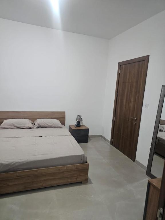 a bedroom with a bed and a wooden door at Maisonette Gzira in Il-Gżira