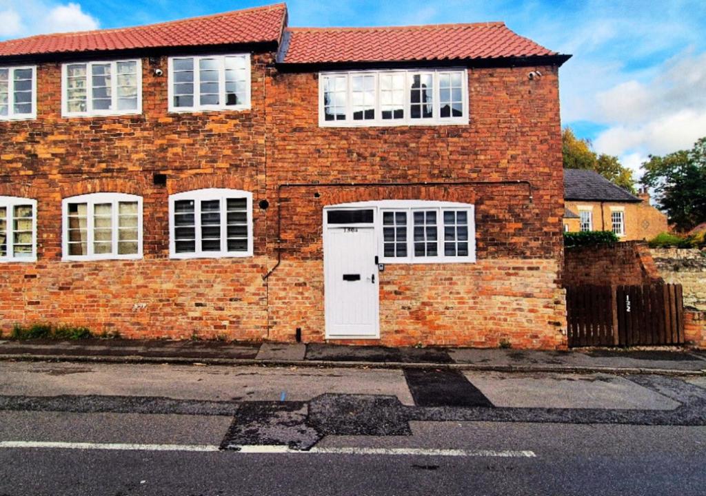 a brick house with a white door and windows at Spacious & Luxury 2BR Flat in Calverton in Calverton