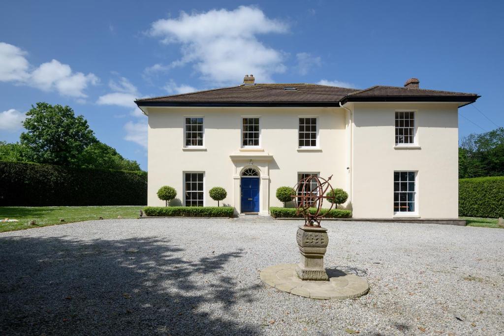 a large white house with a blue door at The Old Vicarage in Wadebridge