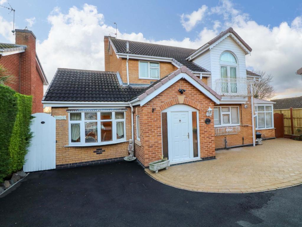 a large brick house with a white garage at Ivy's End in Loughborough