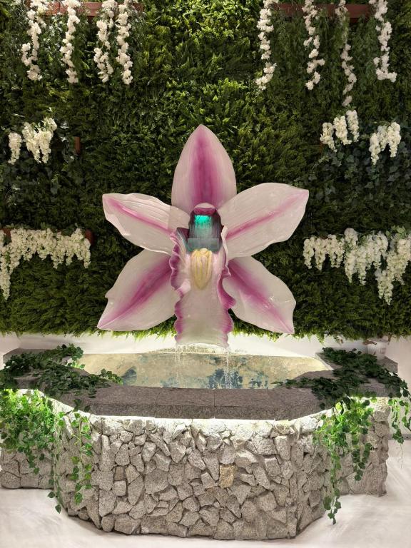 a pink flower sitting on top of a fountain at Hotel Normandie - by Easy Hotéis in Sao Paulo