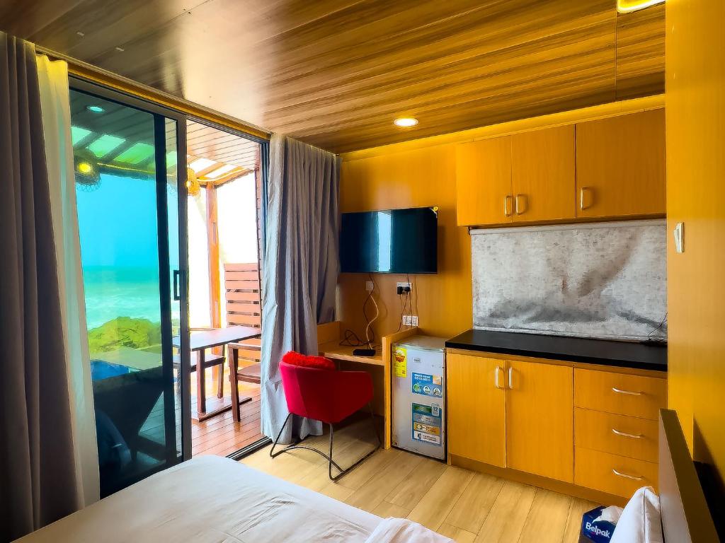 a hotel room with a bed and a desk with a view at Adepa in Kokrobite
