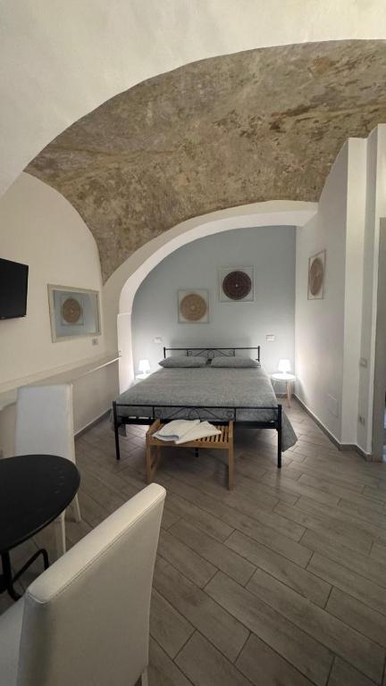 a bedroom with a bed and a table in a room at Petros rooms&apartments in Salerno