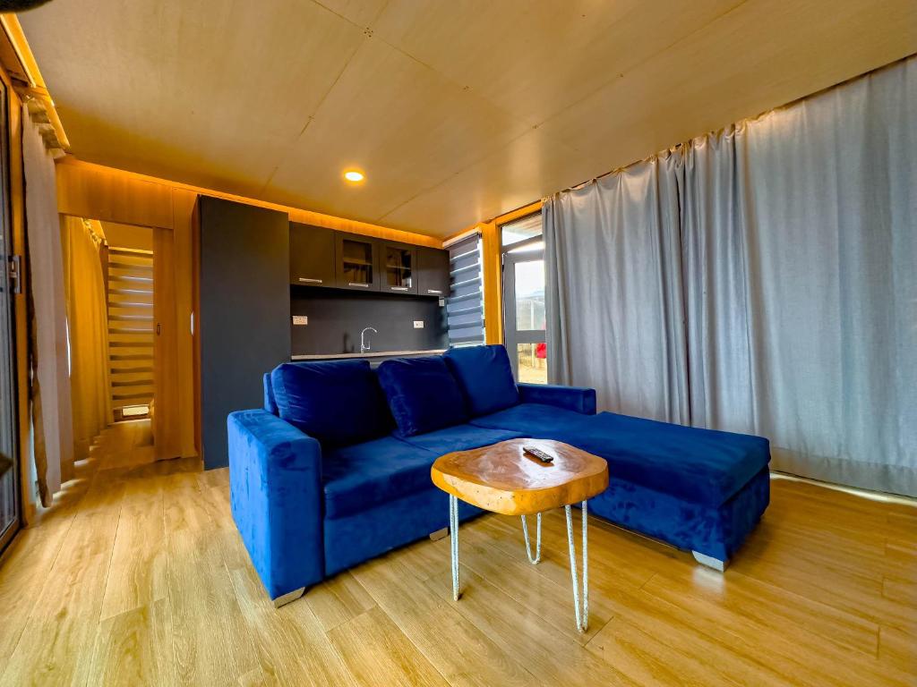 a living room with a blue couch and a table at Akoma in Kokrobite