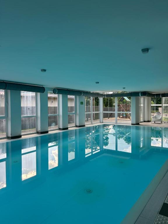 a swimming pool with blue lights in a building at Fresh Garden Casa Mimo in Siófok