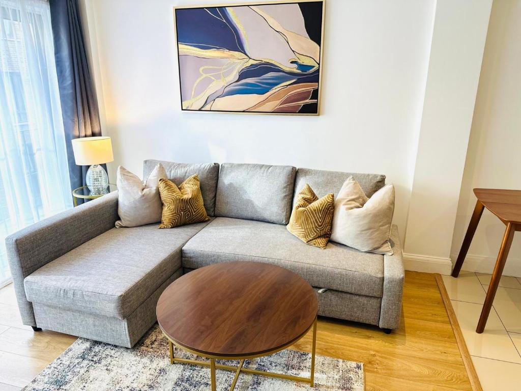 een woonkamer met een bank en een salontafel bij Westferry Deluxe Apartment 3 in Londen
