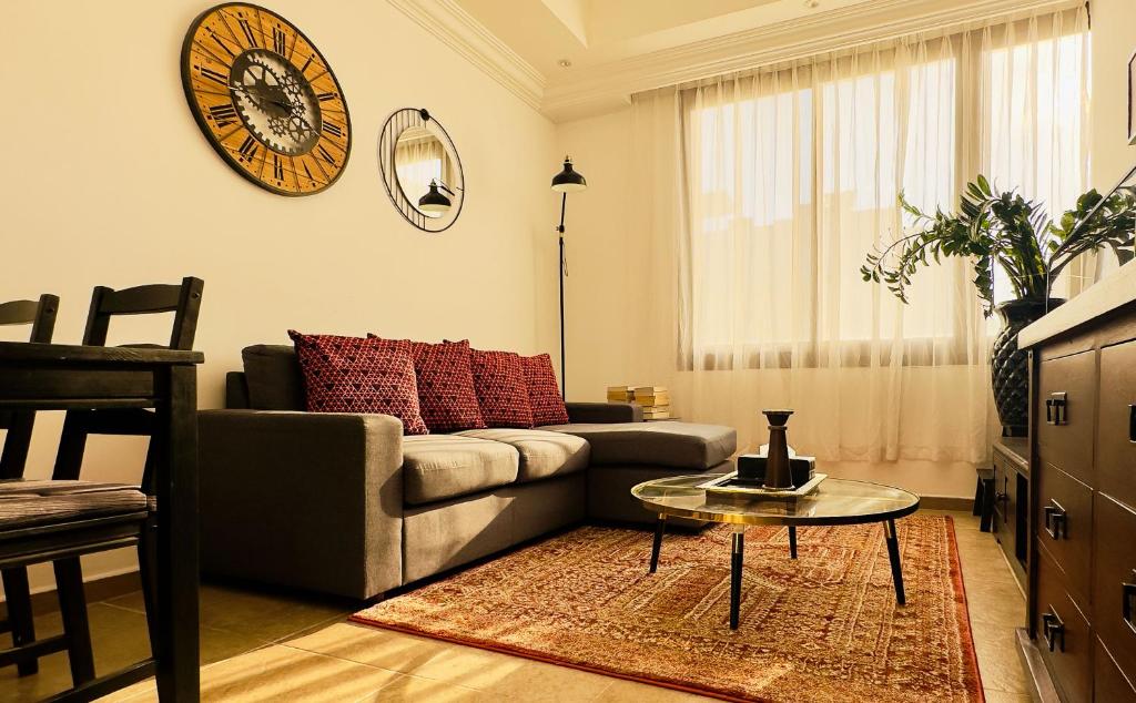 a living room with a couch and a table at Mid-Century Modern Comfort 1BR in Abu Dhabi
