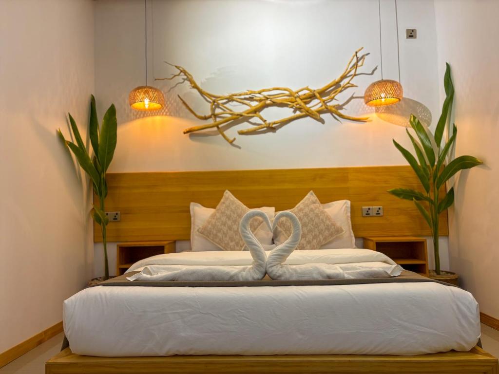 een slaapkamer met een bed met een strik erop bij Eco Palm Maldives in Mathiveri