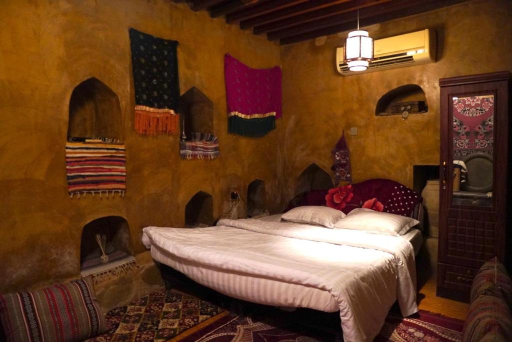 una camera da letto con un letto e bandiere alle pareti di حياه العقر hayat alaqar a Nizwa