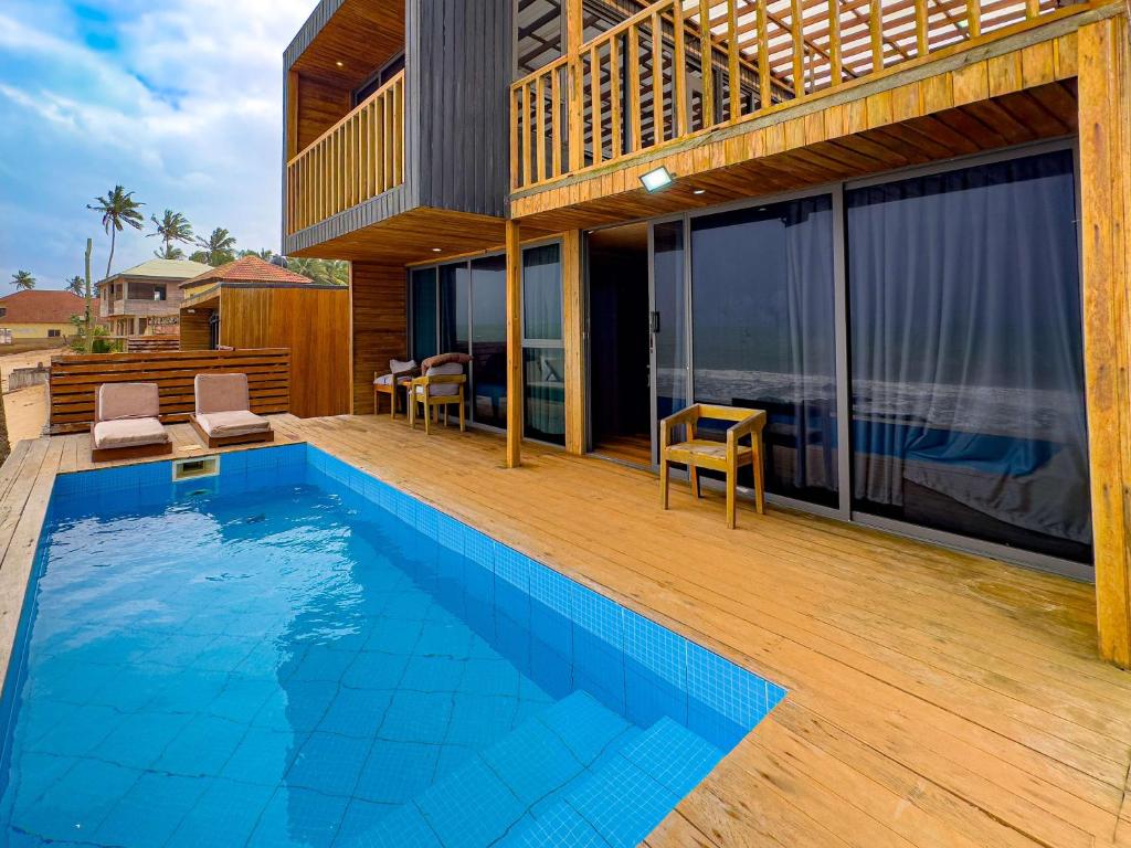 una casa con piscina en una terraza de madera en Azumah, en Kokrobite