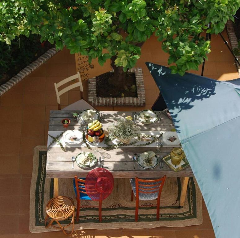 een uitzicht op een houten tafel met stoelen bij El Patio del Limonero in Écija