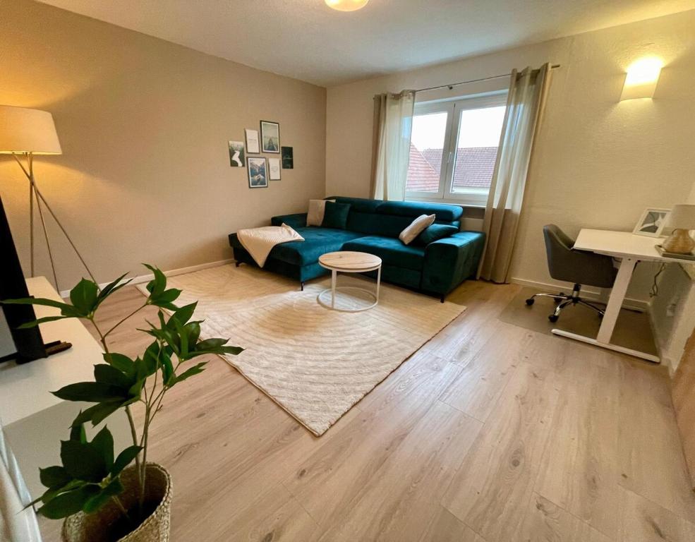 a living room with a blue couch and a table at Lichtblick in Goldbach