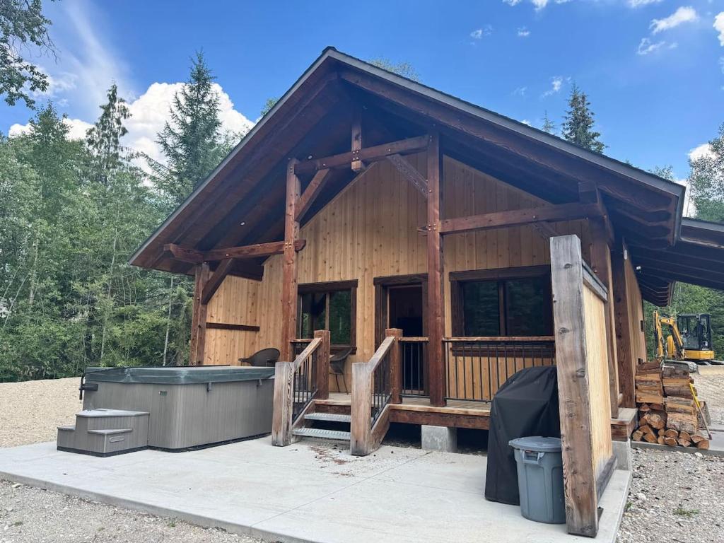 a log cabin with a hot tub in front of it at Explorer Creekside Cabin - Private Hot Tub in Golden