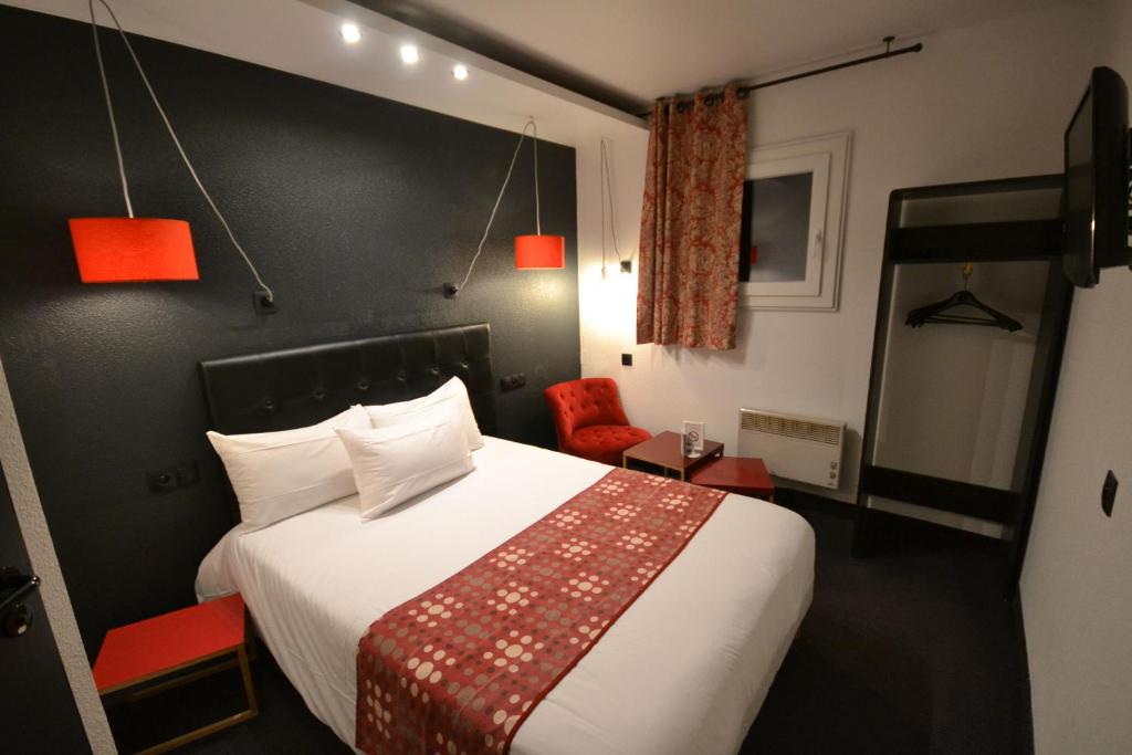 a hotel room with a bed and a red chair at BRIT Hotel - Montsoult La Croix Verte in Baillet-en-France