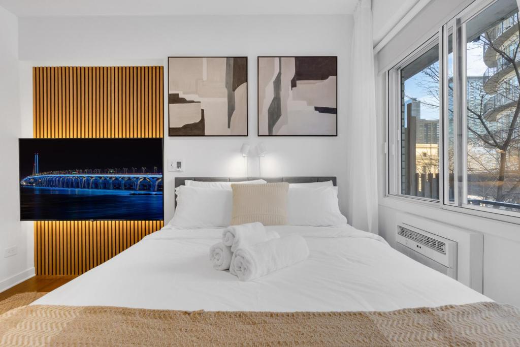 a white bedroom with a large bed with white sheets at The Sherbrooke Suite 101 in Montreal