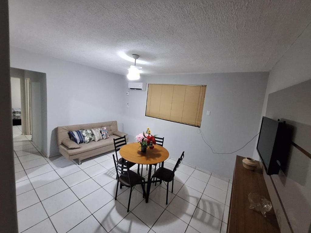 ein Wohnzimmer mit Tisch, Stühlen und Sofa in der Unterkunft Sossego 2 in Várzea Grande