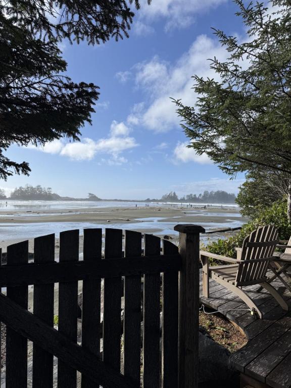 two chairs sitting on a deck looking at the beach at Chesterman on the Point - Beachfront in Tofino