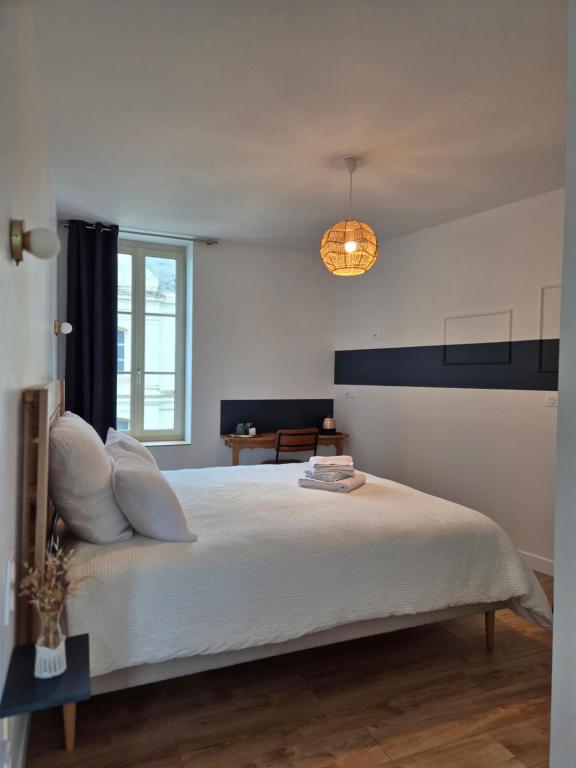 Saint-Rémy-la-VarenneLes chambres de Marcel的卧室里有一张白色的大床和一盏灯