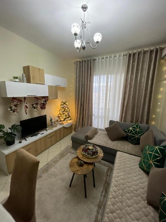 un soggiorno con divano e albero di Natale di The Guest Apartment 2025 a Fier