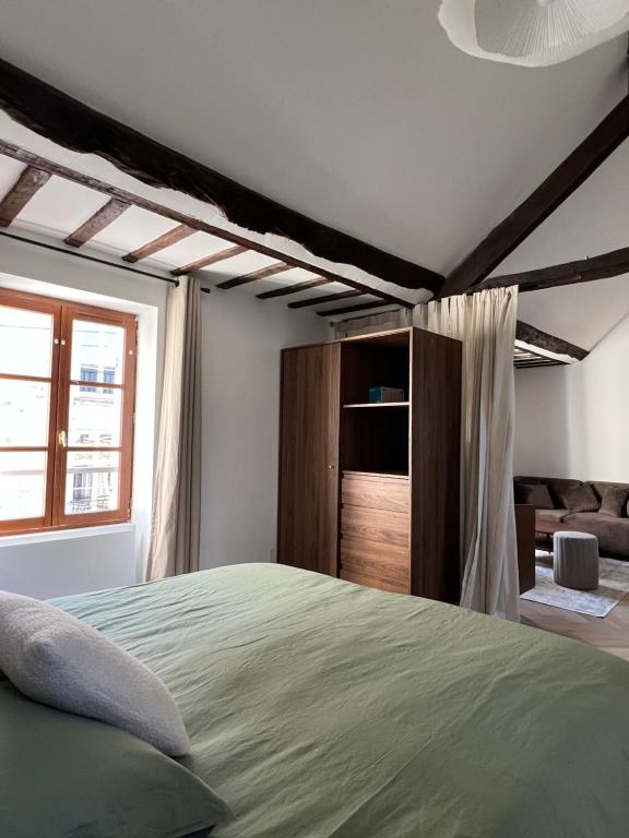 ein Schlafzimmer mit einem Bett und einem Fenster in der Unterkunft Le Nid Bellifontain - Appartement Confort - Centre in Fontainebleau