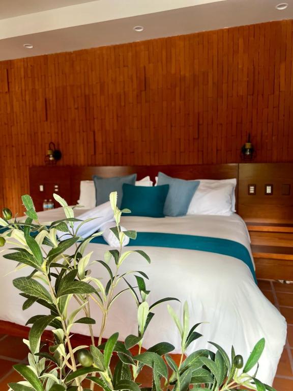 a bedroom with a bed with blue and white pillows at Hotel Boutique Casa Gopar in Ocotlán de Morelos