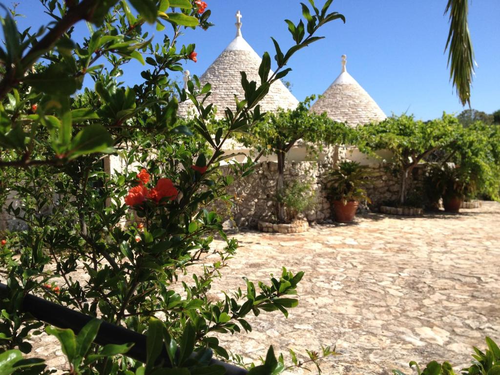 un groupe de bâtiments plantés d'arbres et de fleurs dans l'établissement Masseria Sciaiani Piccola, à Villa Castelli