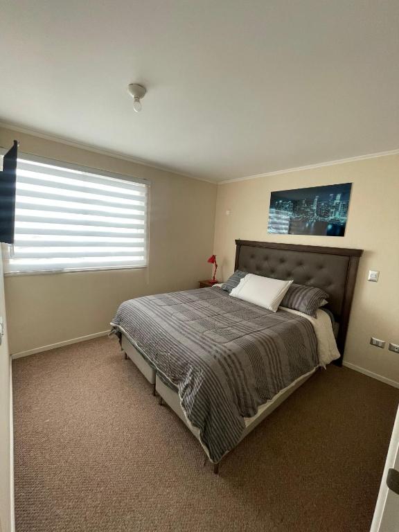 Un dormitorio con una cama grande con ventana. en habitacion doble con baño en suite, en Valdivia