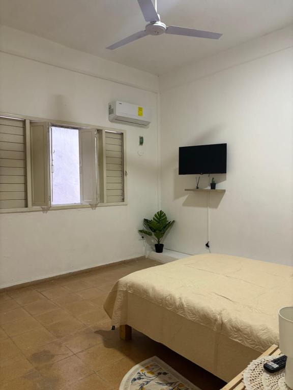 a bedroom with a bed and a flat screen tv at Centrico departamento en el corazon de Cancun a 5 mins del ADO in Cancún