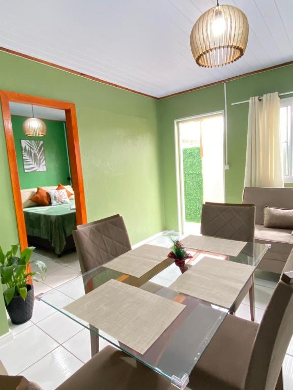 a dining room with green walls and a table and chairs at Casa das Oliveiras in Torres