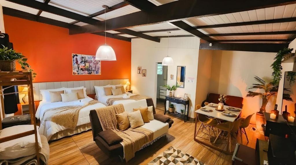 een slaapkamer met een bed en een bank in een kamer bij Pousada Villa Bergamin, Monte Verde in Monte Verde