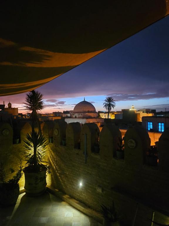 a view of a city at night with a mosque at Suite Les Trois Arches Djamila in Kairouan