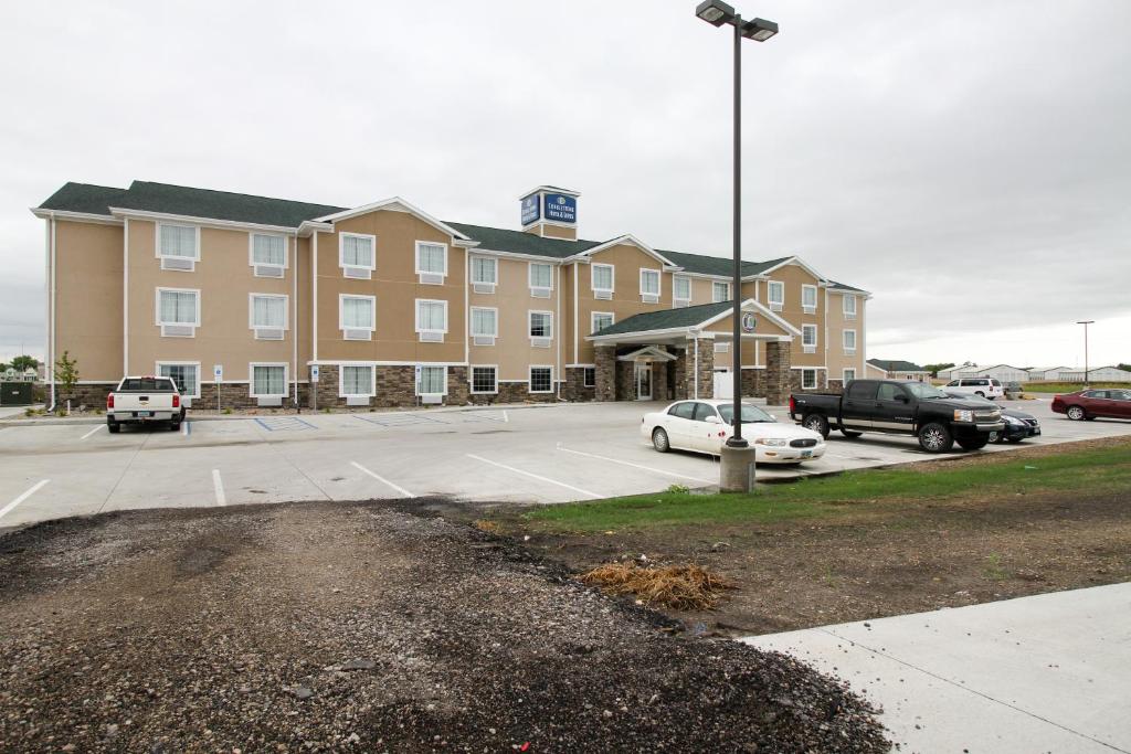 a parking lot in front of a hotel at Cobblestone Hotel & Suites - Devils Lake in Devils Lake
