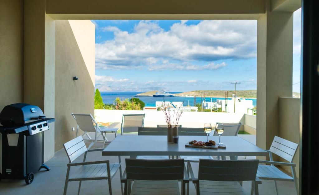 a dining room with a table and chairs and a view of the ocean at Villa Artemis 3 - Etheras Properties in Diakofti