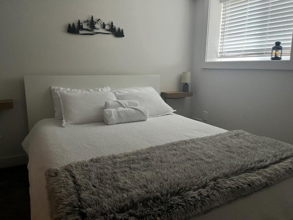 ビクトリアにあるCedar & Sage Suite the Cozy Retreat with Full Kitchenのベッドルーム(白いベッド、毛布付)