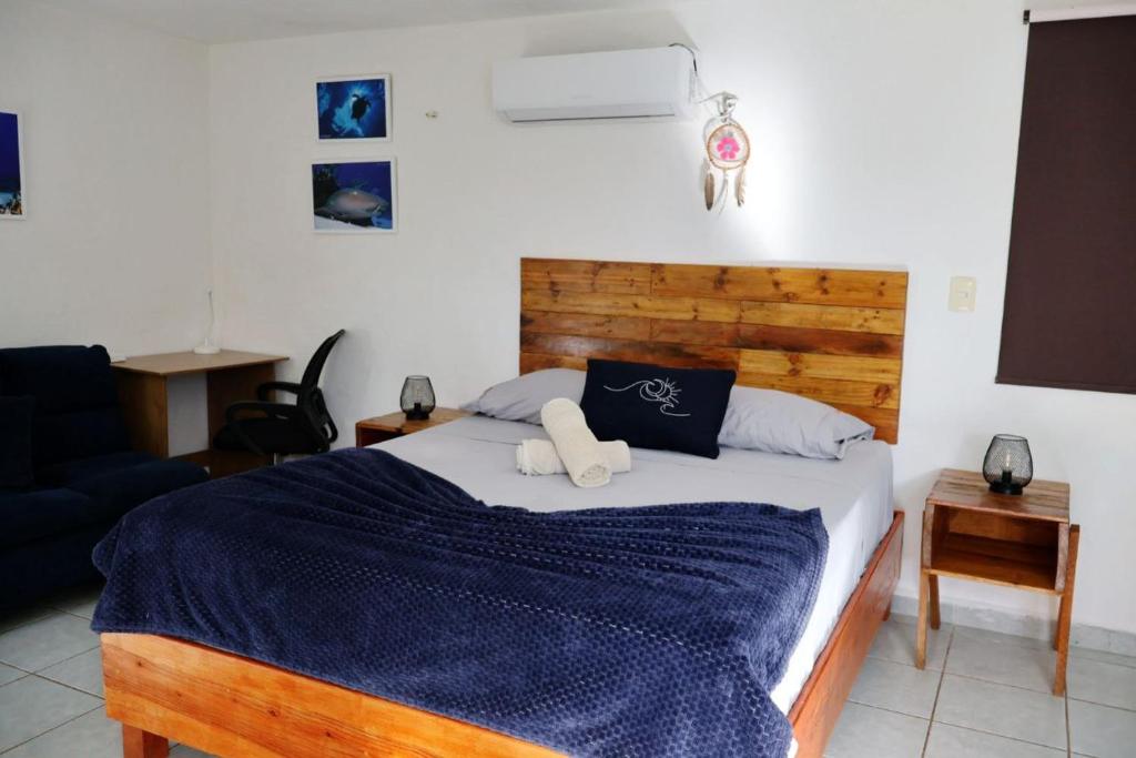 Un dormitorio con una cama grande con una manta azul. en Equipped Yaxkin Studio on downtown, 3 blocks away from sea, close to restaurants, en Cozumel