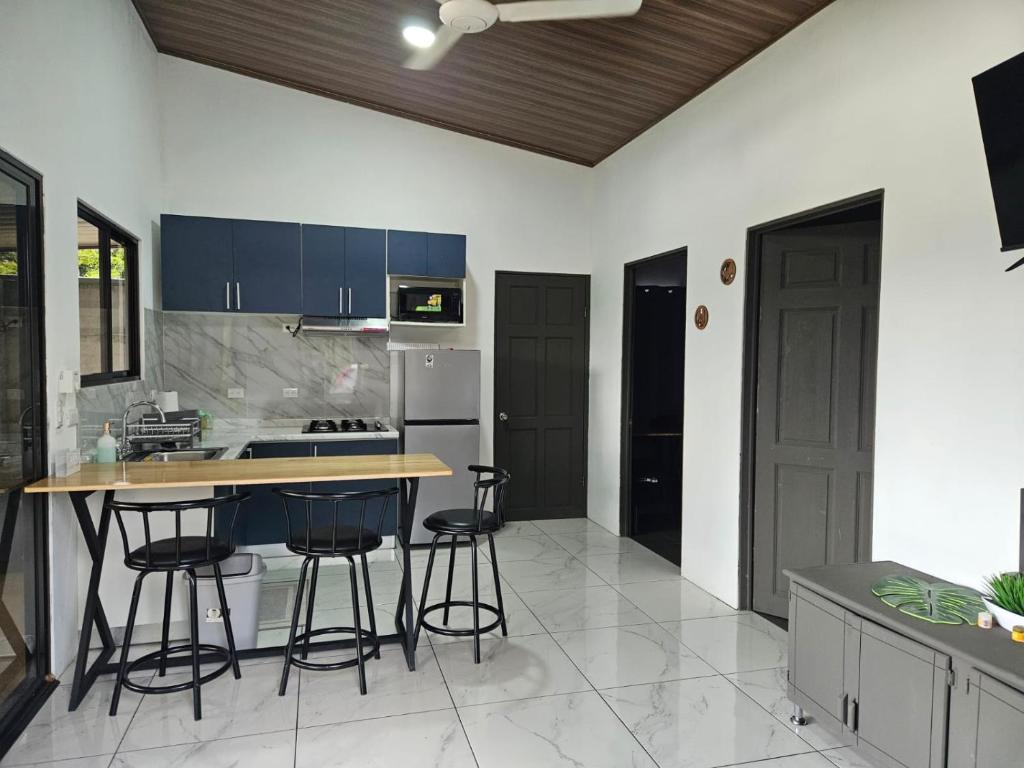 a kitchen with blue cabinets and a counter with stools at Paso de las Lapas in Uvita