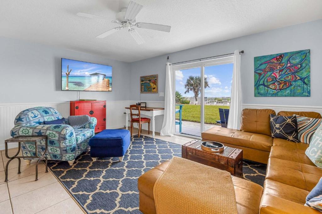 a living room with a couch and a table at Oceanview Escape Private Beach Access in South Cocoa Beach