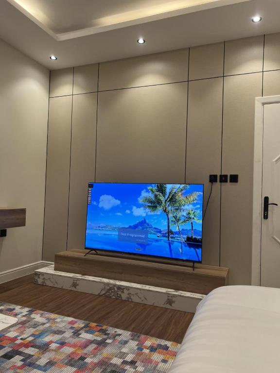 ein Schlafzimmer mit einem Flachbildfernseher an der Wand in der Unterkunft Studio Apartments in Sulaymaniyah in Riad