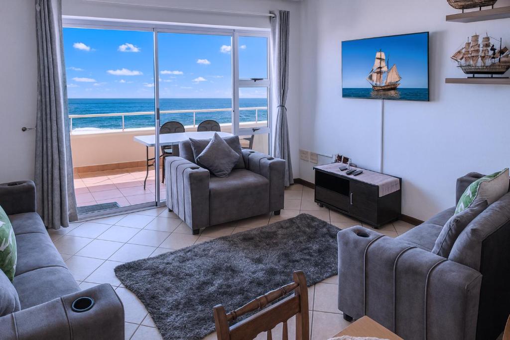 a living room with a view of the ocean at 606 L'esclaier Cabanas - Seaside Paradise in Amanzimtoti