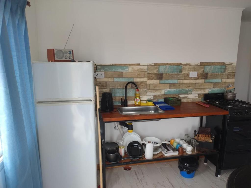 una cucina con un frigorifero bianco e un lavello di Cabañas ohana a Camet Norte