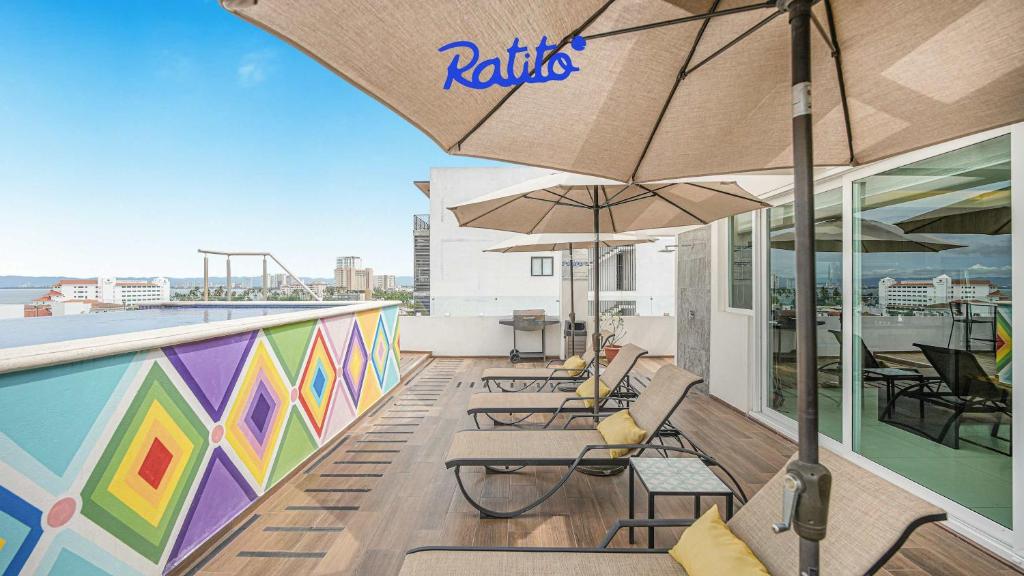 un balcon avec des chaises et des parasols sur un immeuble dans l'établissement 4B Torre KU 2BR Sofa OceanViews Private Balcony, à Puerto Vallarta