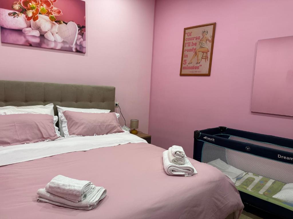 - une chambre avec un lit aux murs roses dans l'établissement Giulieda in Magicland, à Naples